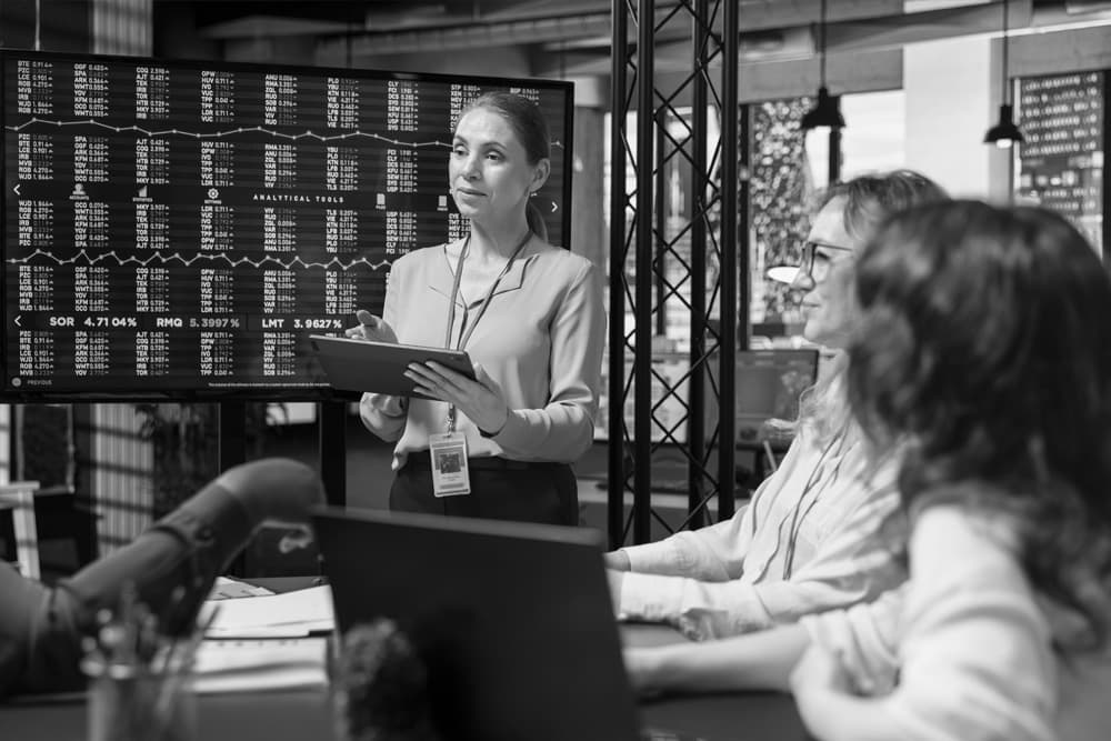 Risk and compliance analysts monitoring live financial data at a control wall