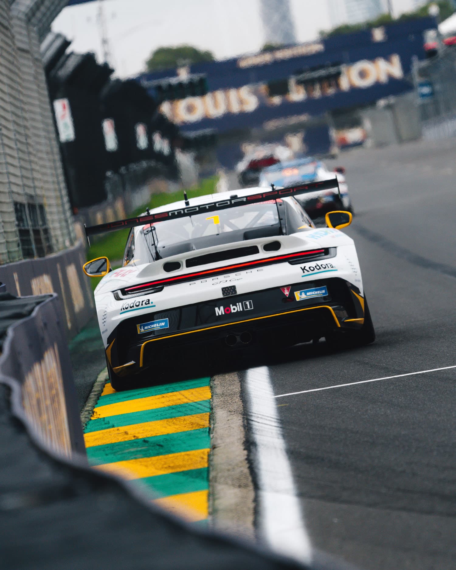 Kodora-liveried Jones Motorsport Porsche 911 at the apex during a Carrera Cup race